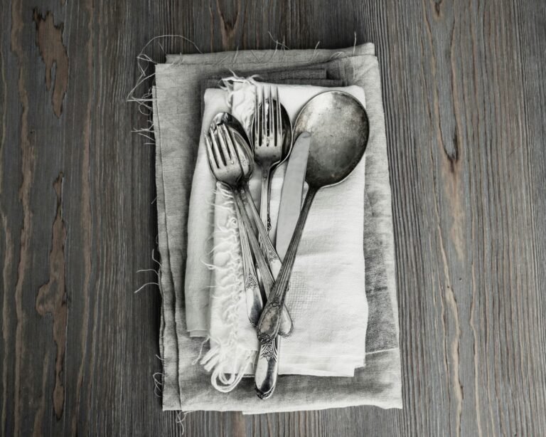 Basic stainless steel cutlery laid out on linen napkins