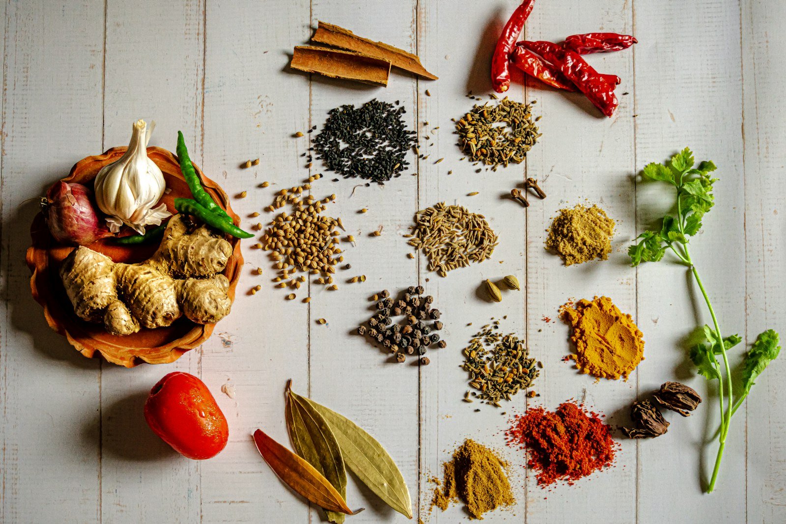 Small bowls of ground spices on a wooden table