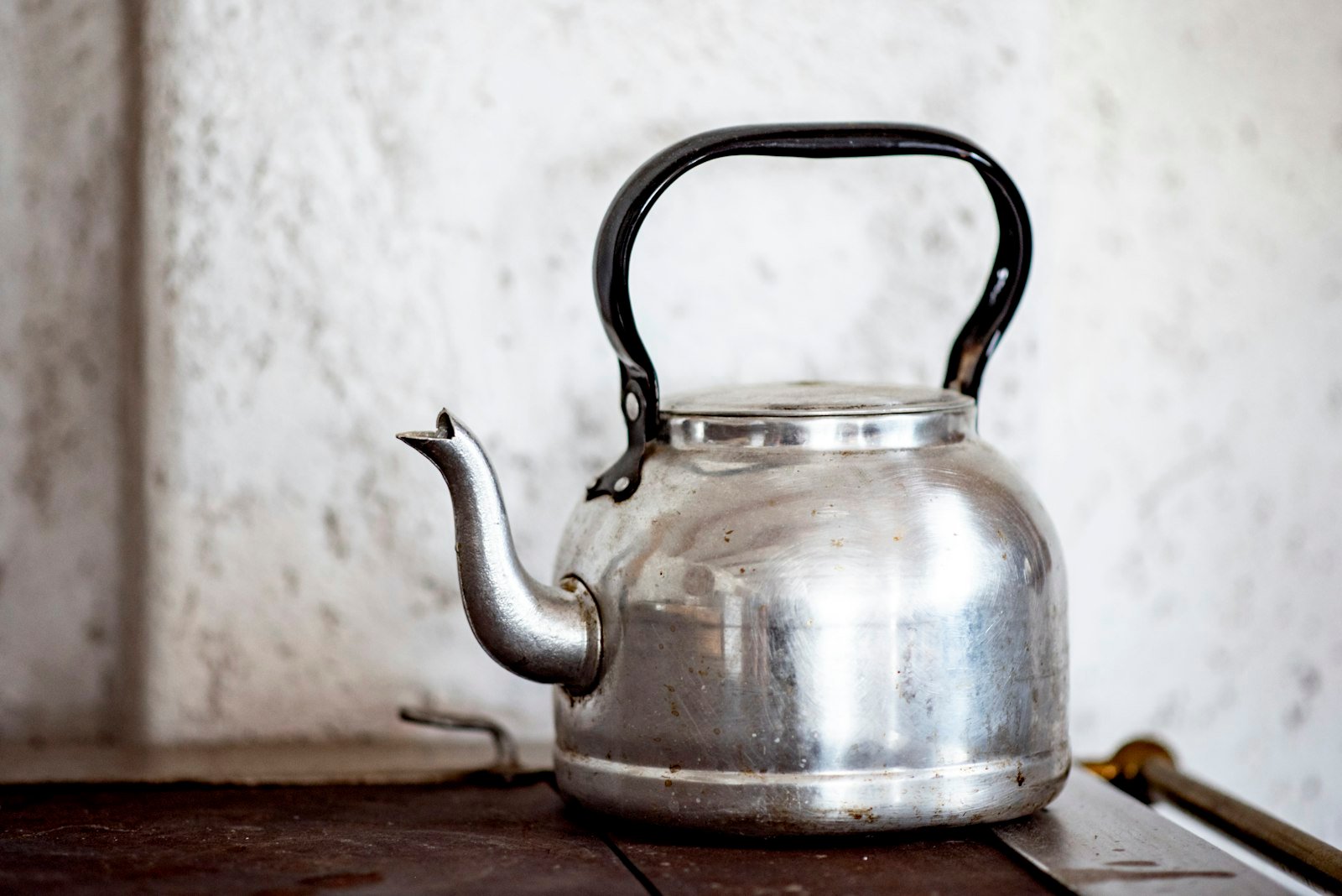 A stainless steel kettle on a wooden kitchen table